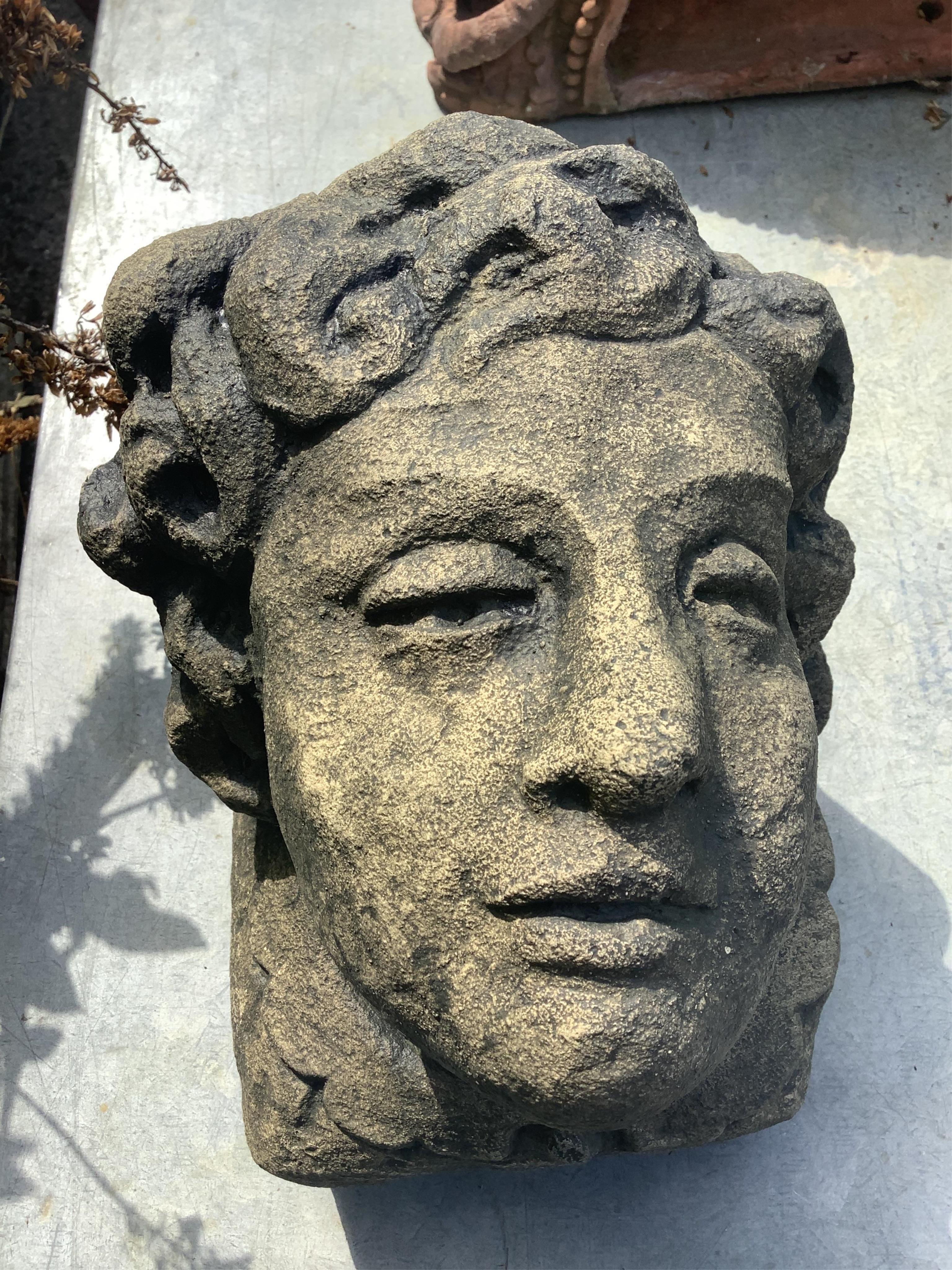 A pair of cast stone mask corbels, height 21cm